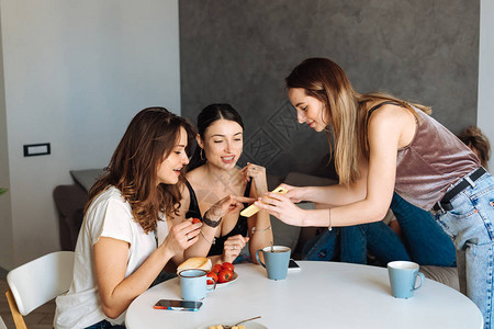 三个女人朋友在厨房吃早餐玩得开心看图片