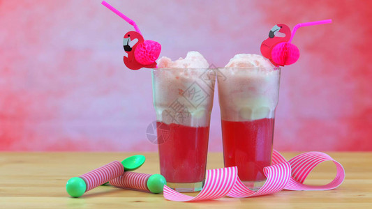 用粉红色的覆盆子汽水和冰淇淋在高大的咖啡杯中制作冰淇淋汽水图片