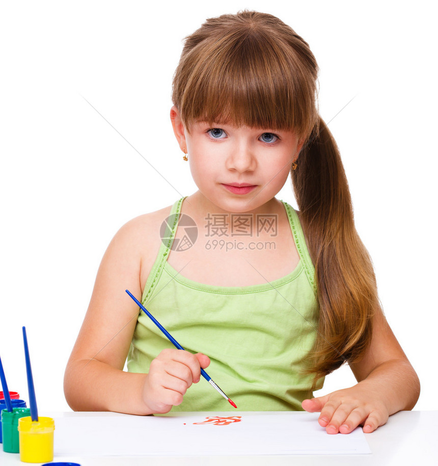 坐在桌边玩涂漆的可爱体贴细心的孩子图片