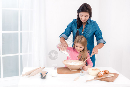 家庭烹饪的甜蜜时光母亲和女儿在准备饭菜时很开心漂亮的白色内饰女儿和图片