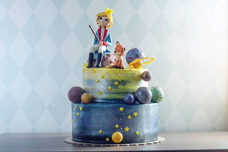 大孩子漂亮的蛋糕以行星的形式装饰着小王子和狐狸的乳香小雕像生日儿童节背景图片