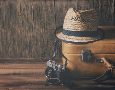 复古案例时髦帽子和复古相机在木制背景静物画上暑假期和冒图片