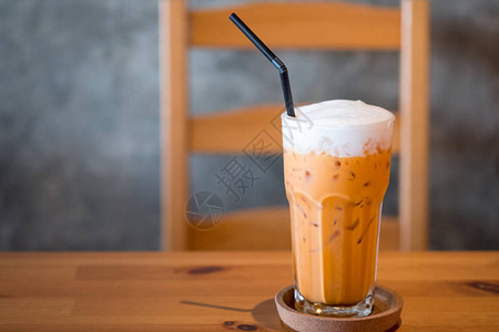 冰奶茶或泰式奶茶装在桌上的玻璃杯中图片