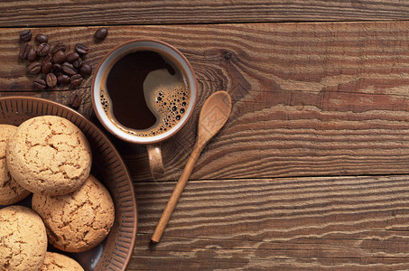 热咖啡和燕麦饼干在旧木制桌板上的盘子图片