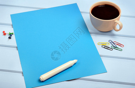 蓝纸桌上有白色记号笔和咖啡杯图片