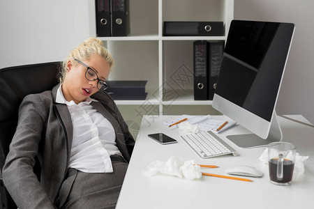 睡觉在办公室的女商人图片