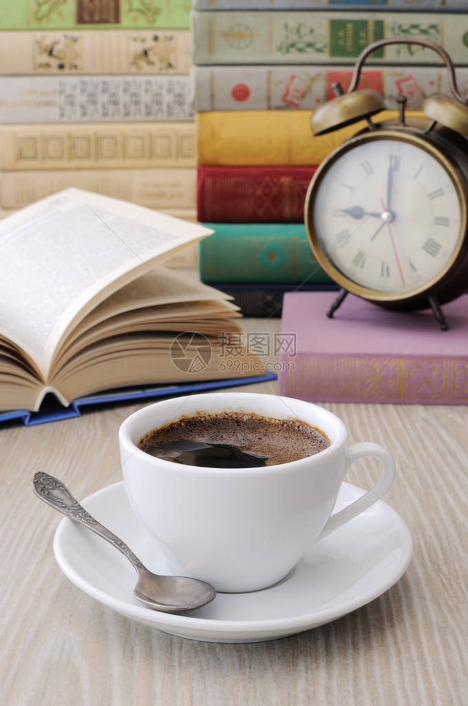 桌子上一杯咖啡背景是一本开着的书有图片