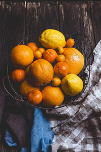 橙子橘子柠檬盘子里的库姆夸特和木桌图片