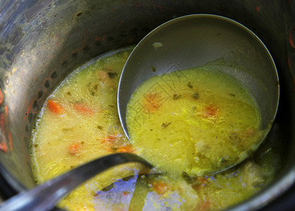 生铁锅配蔬菜汤和勺子图片