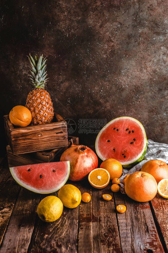 西瓜橙子石榴菠萝和松木制桌图片