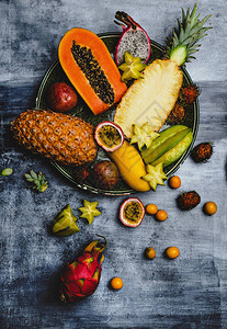 菠萝红毛丹火龙果百香果金橘木瓜杨桃和芒果在餐桌图片