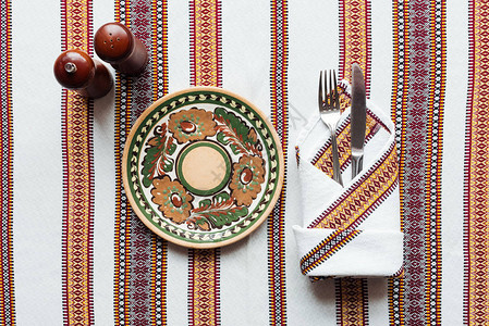 在刺绣桌布上摆有板状的传统餐桌设置图片