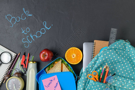 带背包和学习用品的孩子的学校午餐盒和水果图片