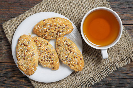 茶杯和燕麦饼干向日葵籽和生锈木制桌子上的芝图片