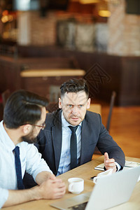 严肃的商人在咖啡休息时间向同事表达他对营销分析的想法商人在喝咖啡休息图片