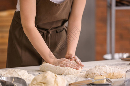 女面包师在厨房里做面团图片