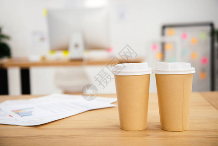 在有办公文件的工作场所近距离观看可支配咖啡杯背景图片