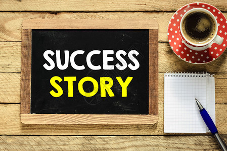 黑板上的成功故事咖啡笔纸和桌子背景图片