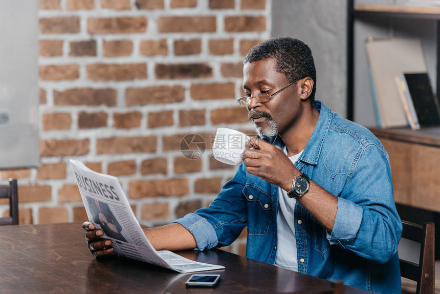 非裔美国人阅读报纸和喝咖图片