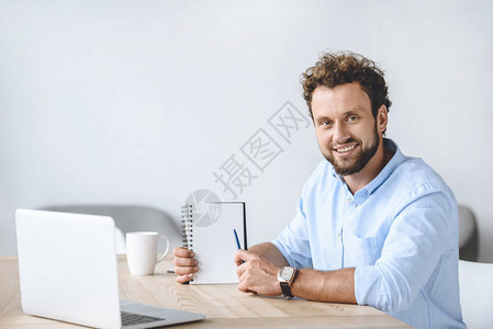 微笑的商人坐在工作场所图片
