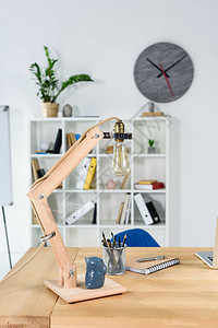 现代办公室内装有木制桌台灯和文具的现图片