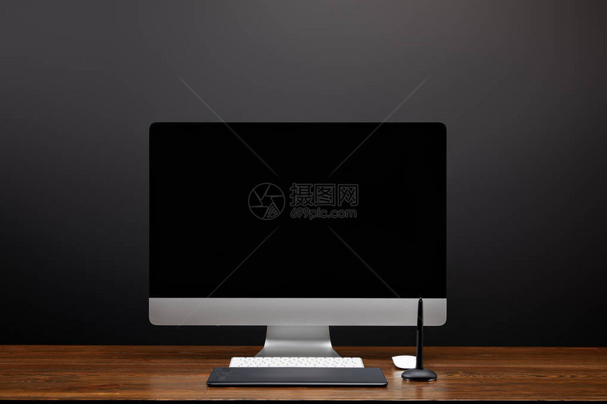 用空白的电脑屏幕和木制桌面上的图形平板电脑关闭设计师工图片