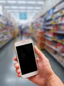 手持智能手机超市背景模糊的So图片
