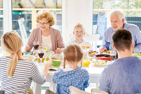 幸福的家庭在节日庆祝期间围坐在节日餐桌旁享用美味佳肴的肖像图片