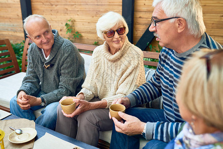 一群快乐的老年人在户外咖啡馆共度时光图片