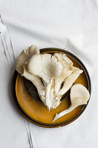 白布上盘子里的蘑菇上视图图片
