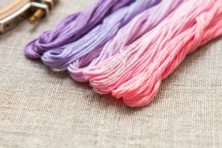 设置刺绣亚麻土布上的紫色和粉红色刺绣线色调着色和处理图片