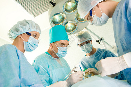 一组外科医生在工作期间看病人手术图片