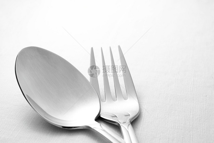 餐桌上餐巾纸上的叉子和勺子图片