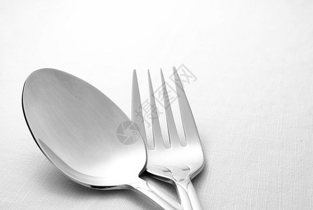 餐桌上餐巾纸上的叉子和勺子图片