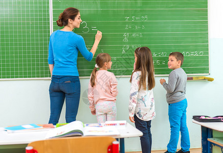 老师和学生站在黑板前数学课图片