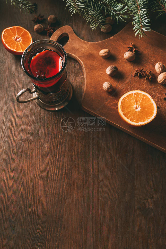 木制切割板上玻璃杯中加香料和橙子的图片