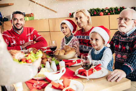 妇女与幸福家庭共餐的圣诞节晚宴用餐在桌旁吃着图片