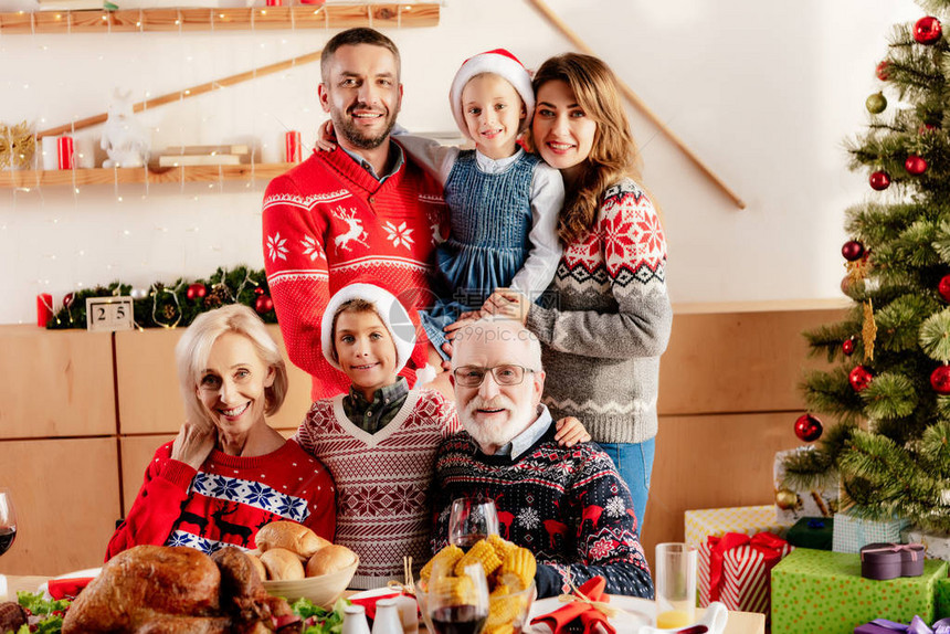家庭幸福家里有小孩穿着圣诞礼帽在圣诞节晚宴时坐图片