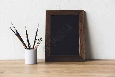 木制桌面上的空相框和油图片