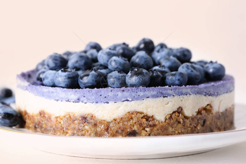 餐桌上有美味的蓝莓芝士蛋糕在光底图片