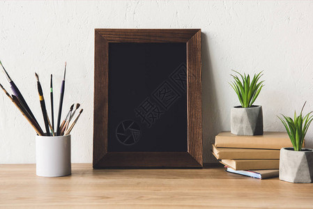 照片框花盆中的植物油漆笔画和木制桌面上背景图片