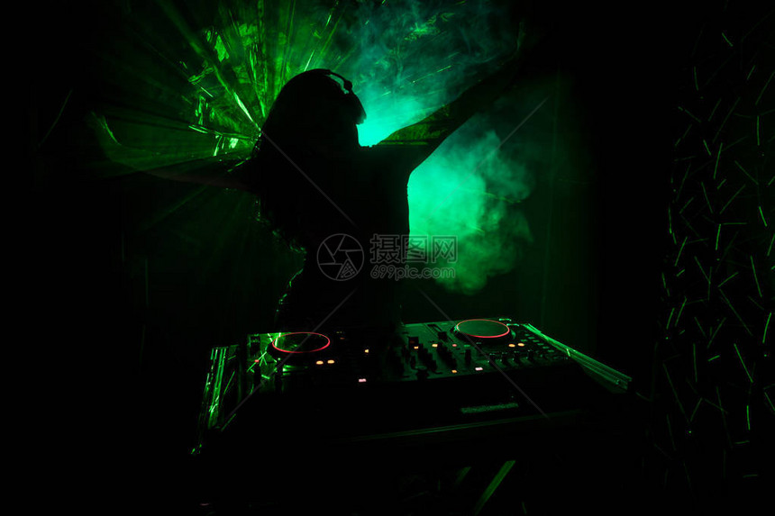 DJ之手调整dj甲板上的各种轨道控制频闪灯和雾图片