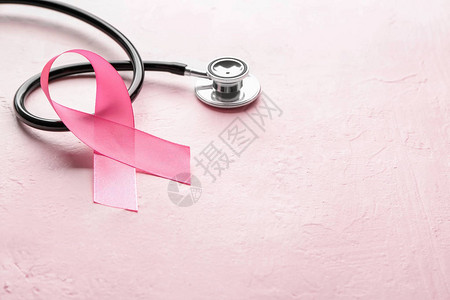 关于肤色背景的粉色丝带和听诊器乳图片