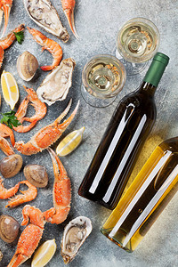 海鲜牡蛎龙虾蛤蜊和白葡萄酒石桌上的顶视图图片
