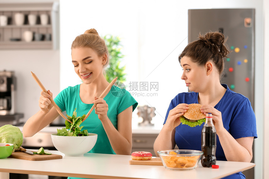 年轻的臭女人吃不健康的食物图片