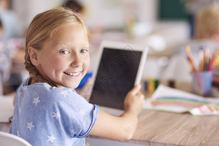 坐在教室里使用数字平板电脑的女孩图片