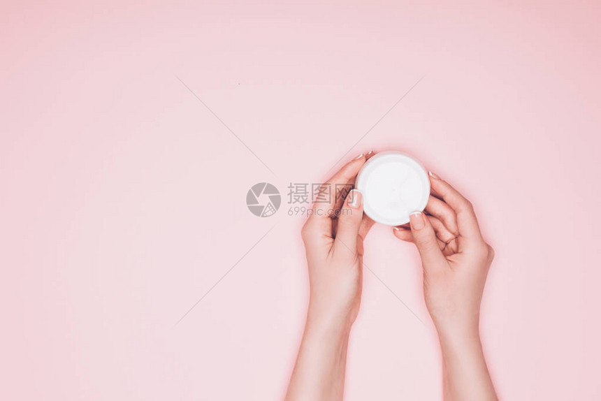 女人拿着一罐被粉色隔开的保湿霜的短片图片