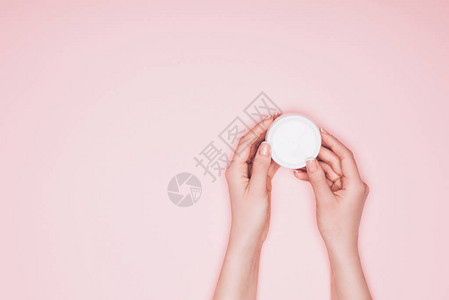 女人拿着一罐被粉色隔开的保湿霜的短片背景图片