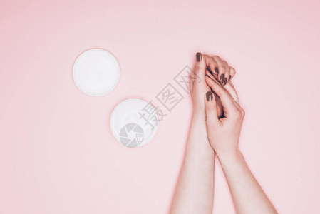 女在粉红色上涂抹护手霜的短片背景图片