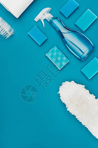 蓝色隔离的喷雾瓶洗涤海绵和灰尘刷的顶部视图图片
